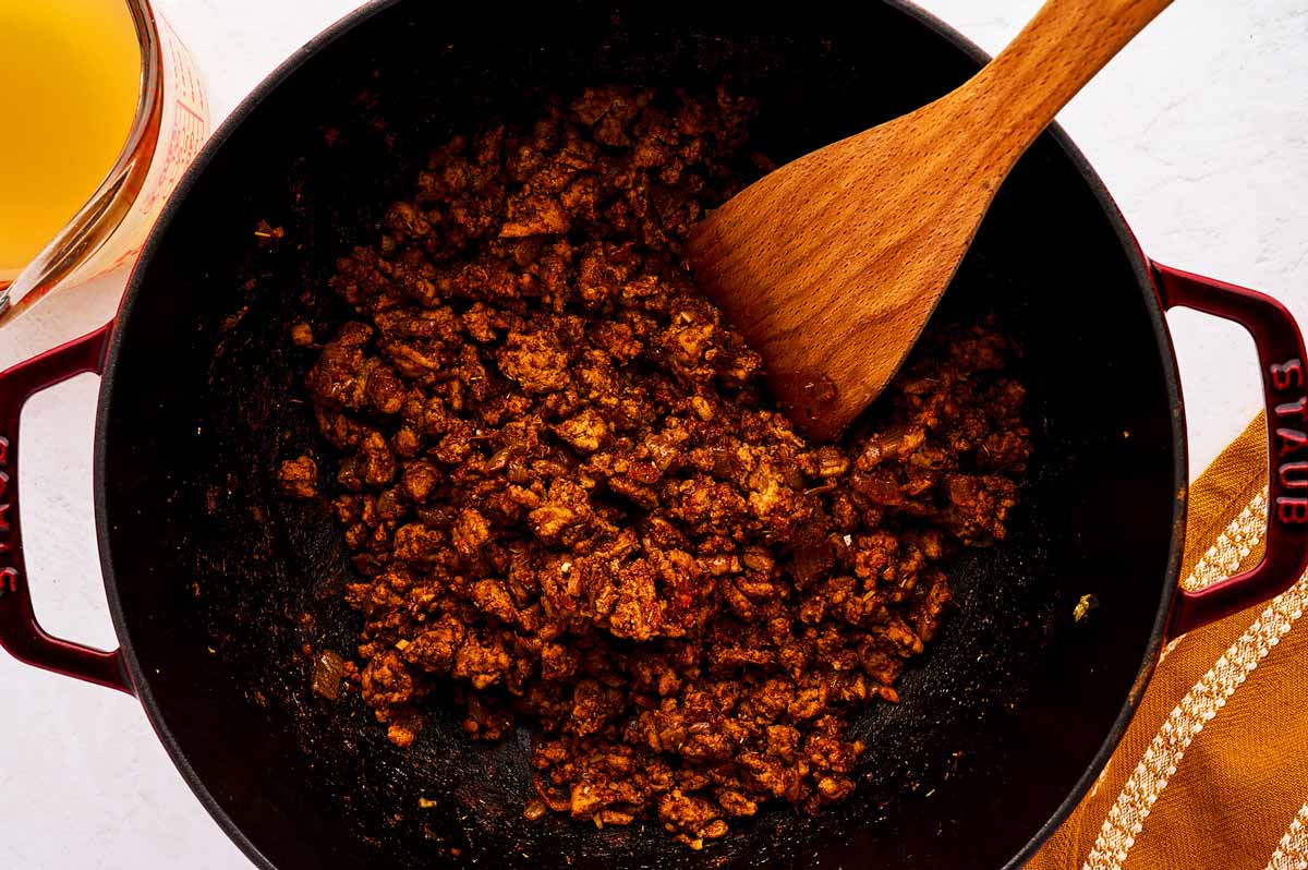 Roasting tomato paste and spices with ground turkey in a Dutch oven.