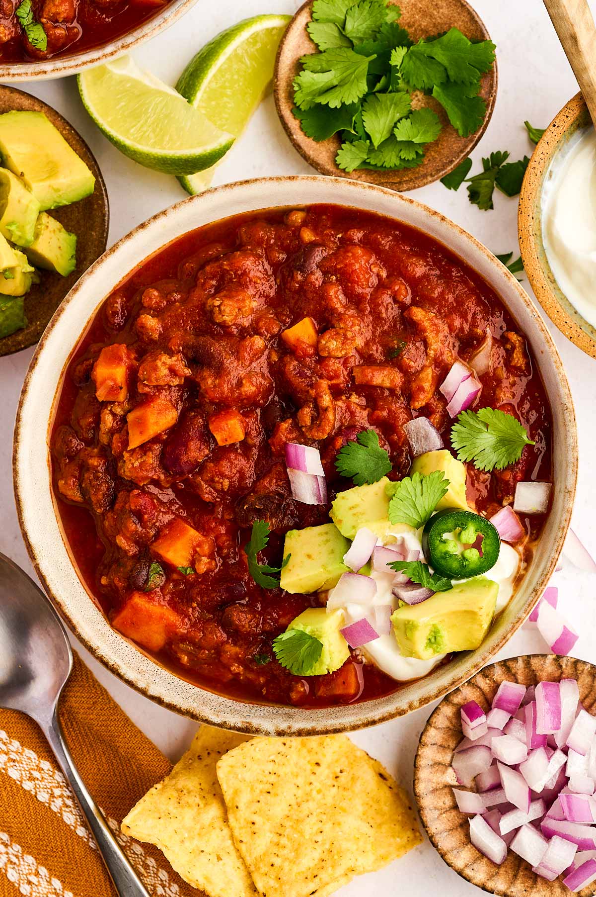 Bowl of turkey chili with toppings.