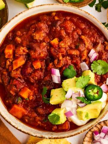 Bowl of turkey chili with toppings.