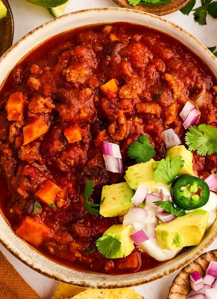 Bowl of turkey chili with toppings.