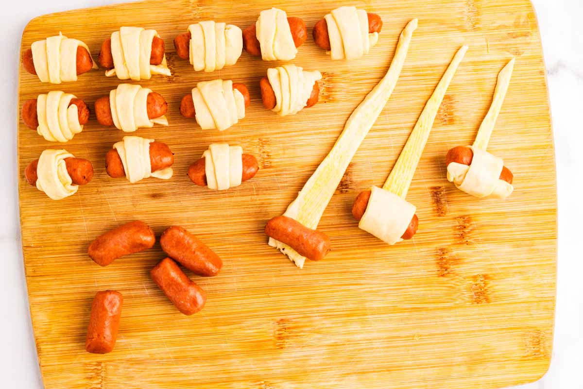 Rolling up pigs in blankets.