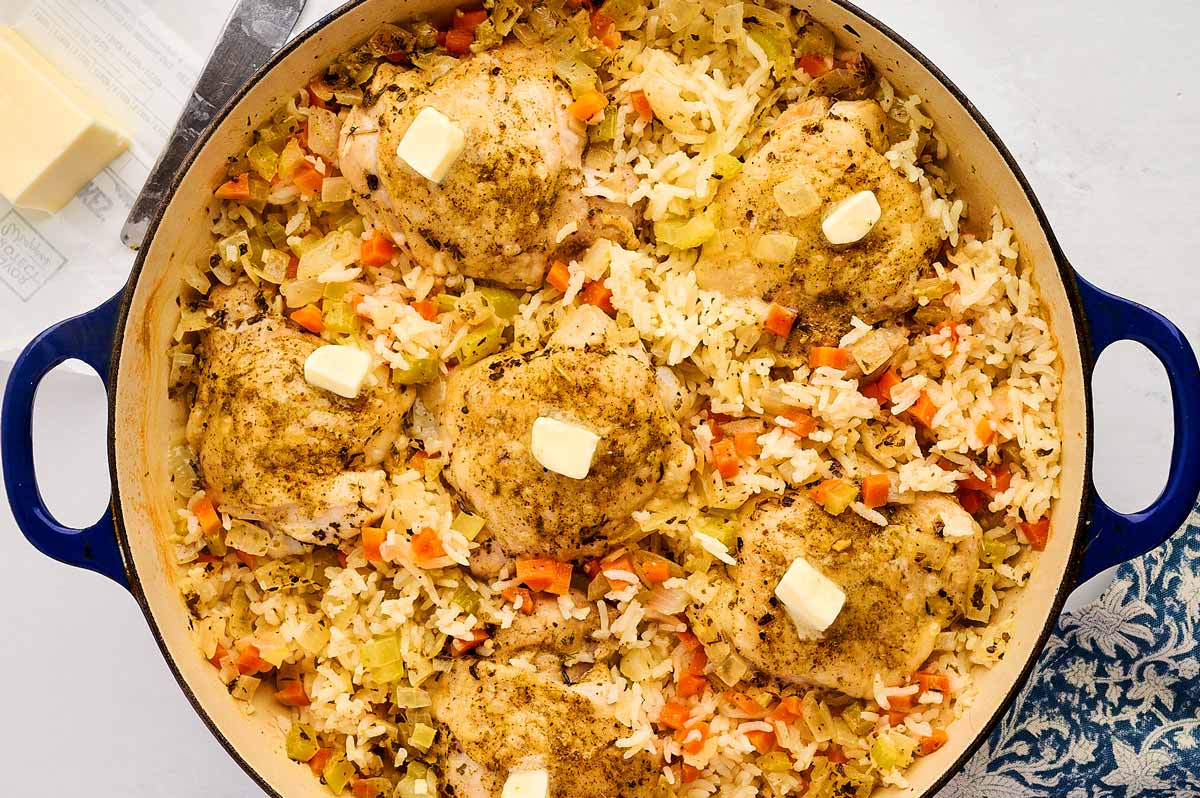 Pats of butter on top of chicken and rice.