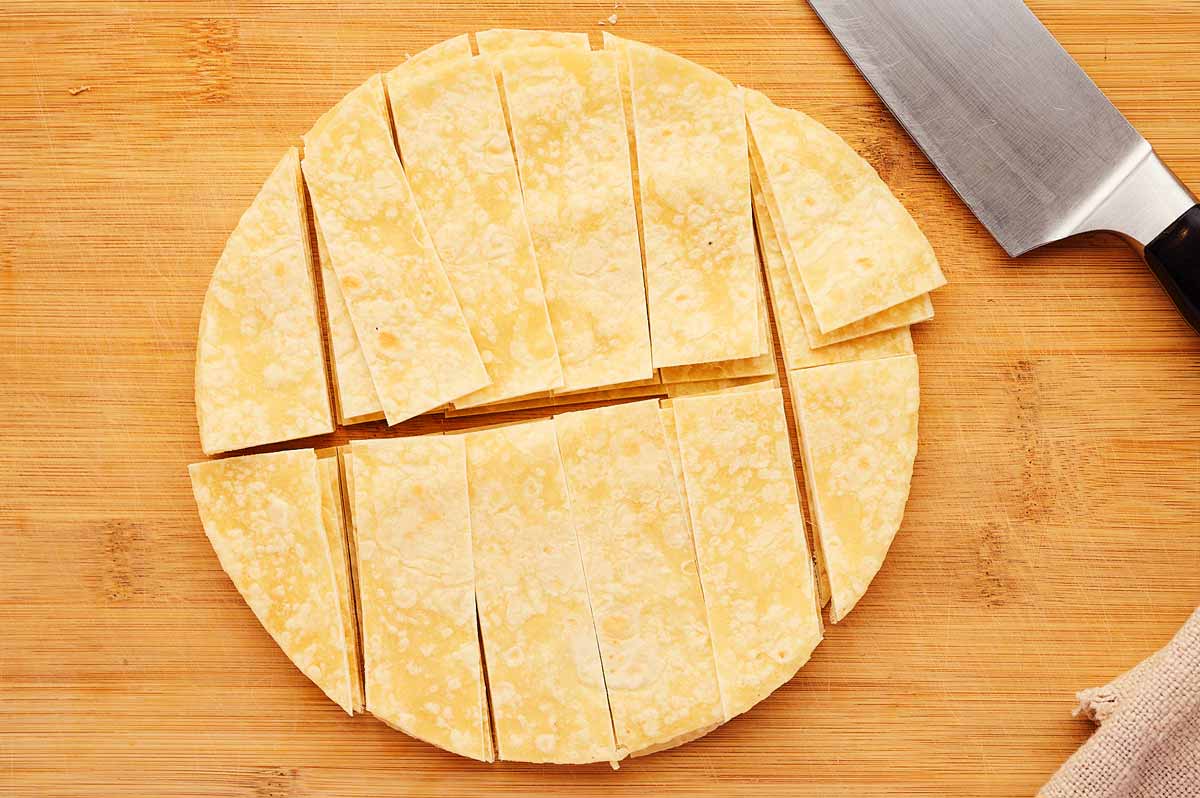 Cutting tortillas into strips.