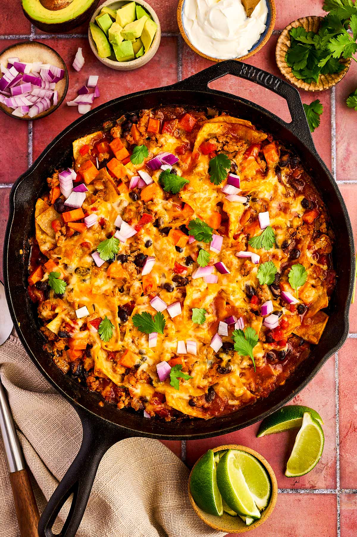 Enchilada Casserole being served from a cast iron skillet.