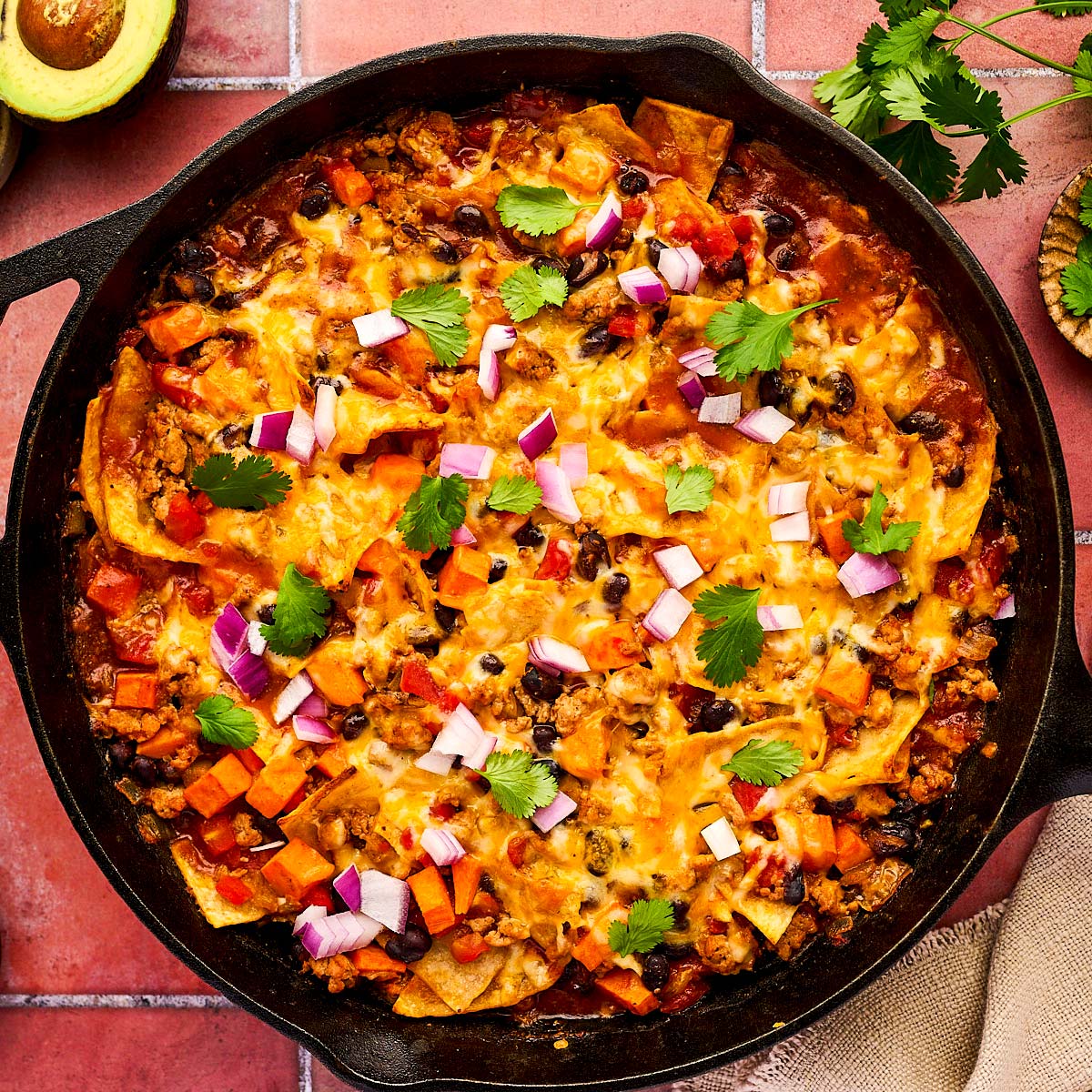 Enchilada Casserole being served from a cast iron skillet.