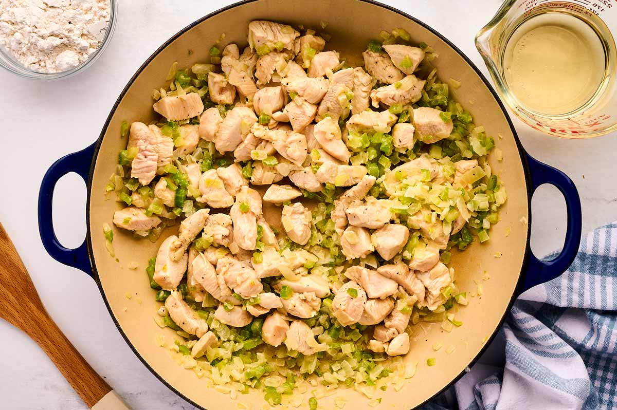 Sautéed vegetables and chicken pieces in braiser.