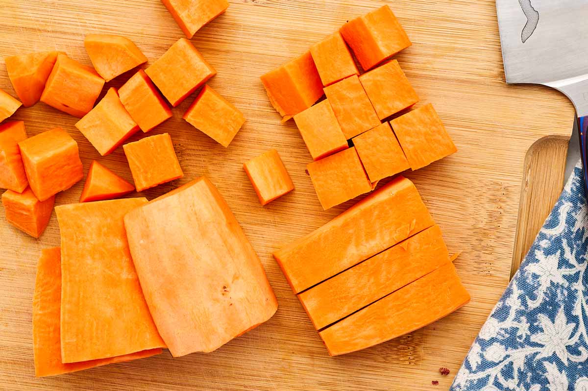 Cutting sweet potatoes into cubes.