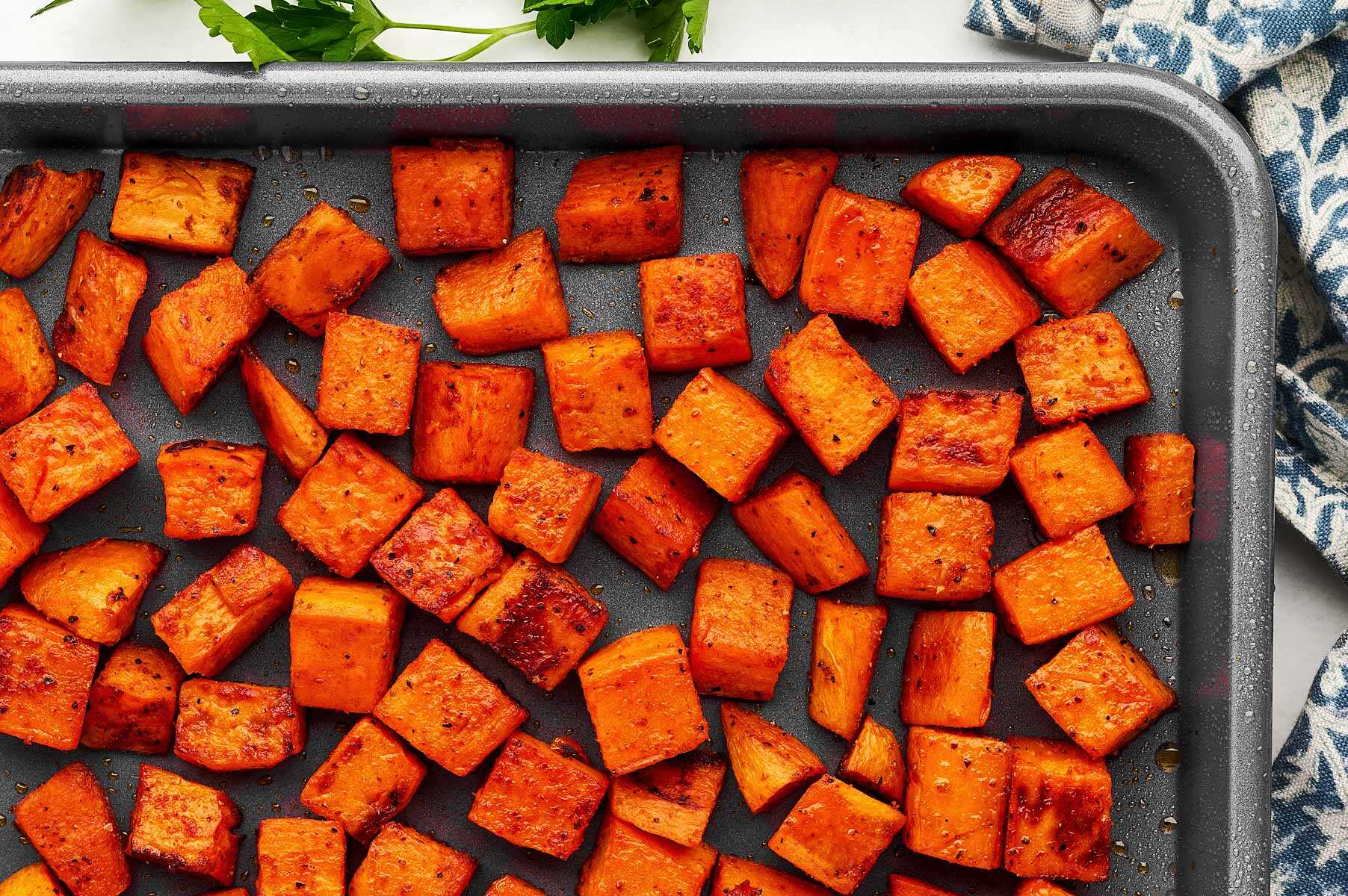 Sheet pan with roasted sweet potato cubes.
