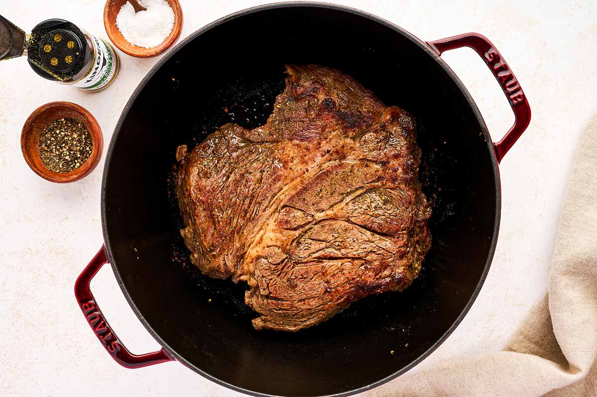 Seared chuck roast in cast iron braiser.