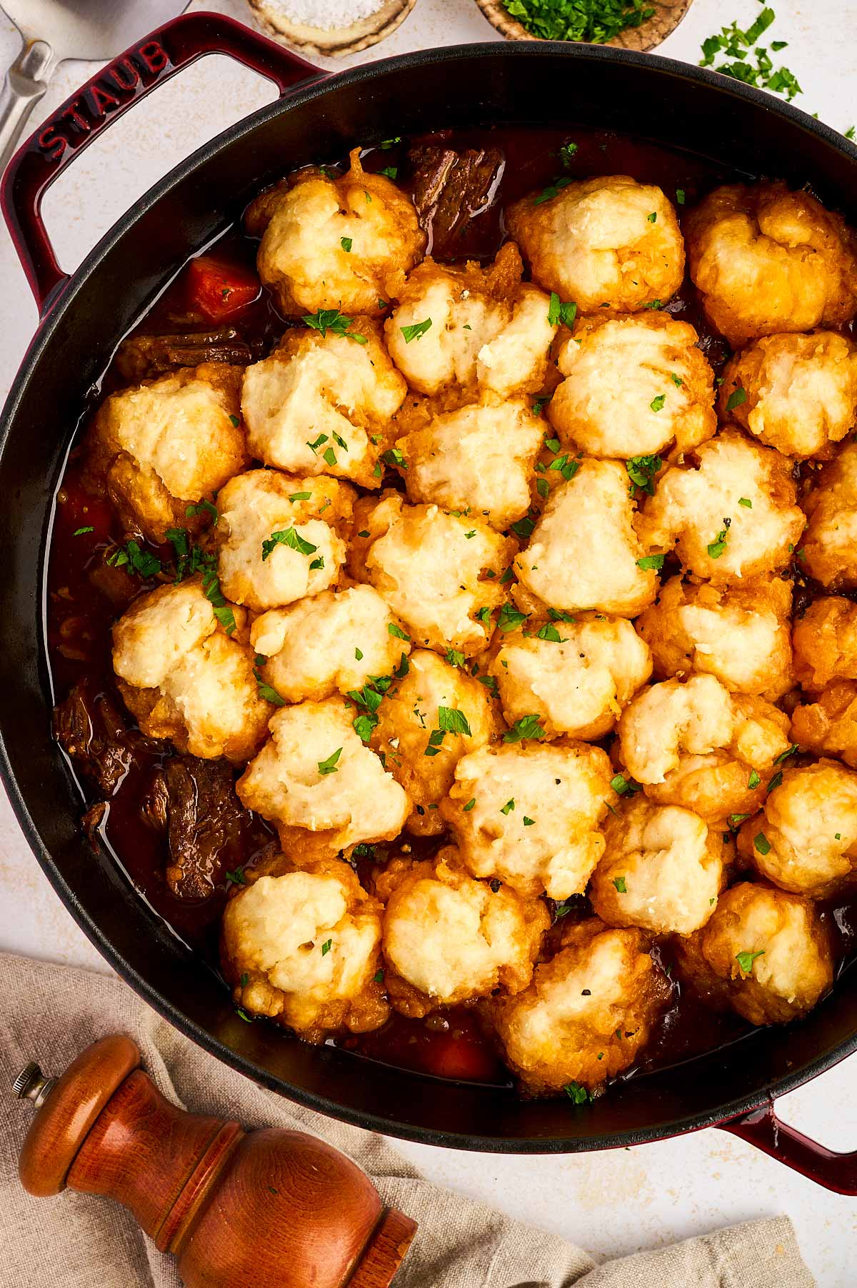Slow cooked beef and dumplings in cast iron pot.