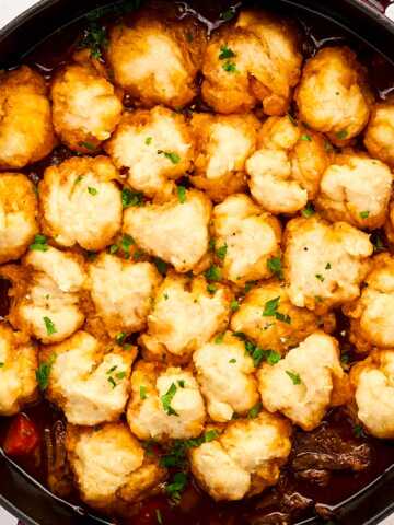 Serving beef and dumplings from a cast iron braiser.