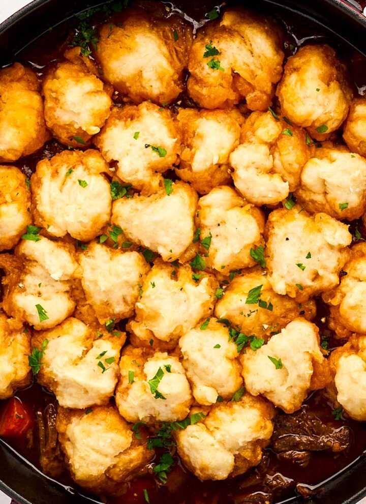 Serving beef and dumplings from a cast iron braiser.