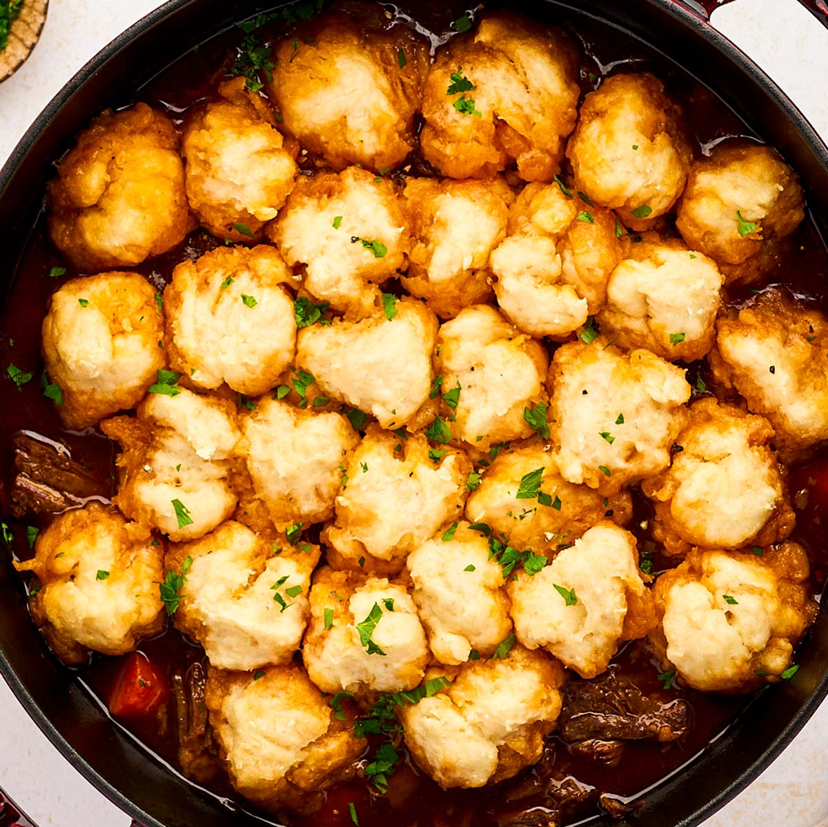 Serving beef and dumplings from a cast iron braiser.