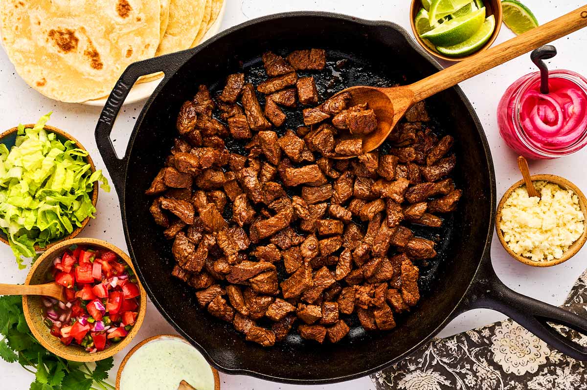 Serving steak tacos with toppings.