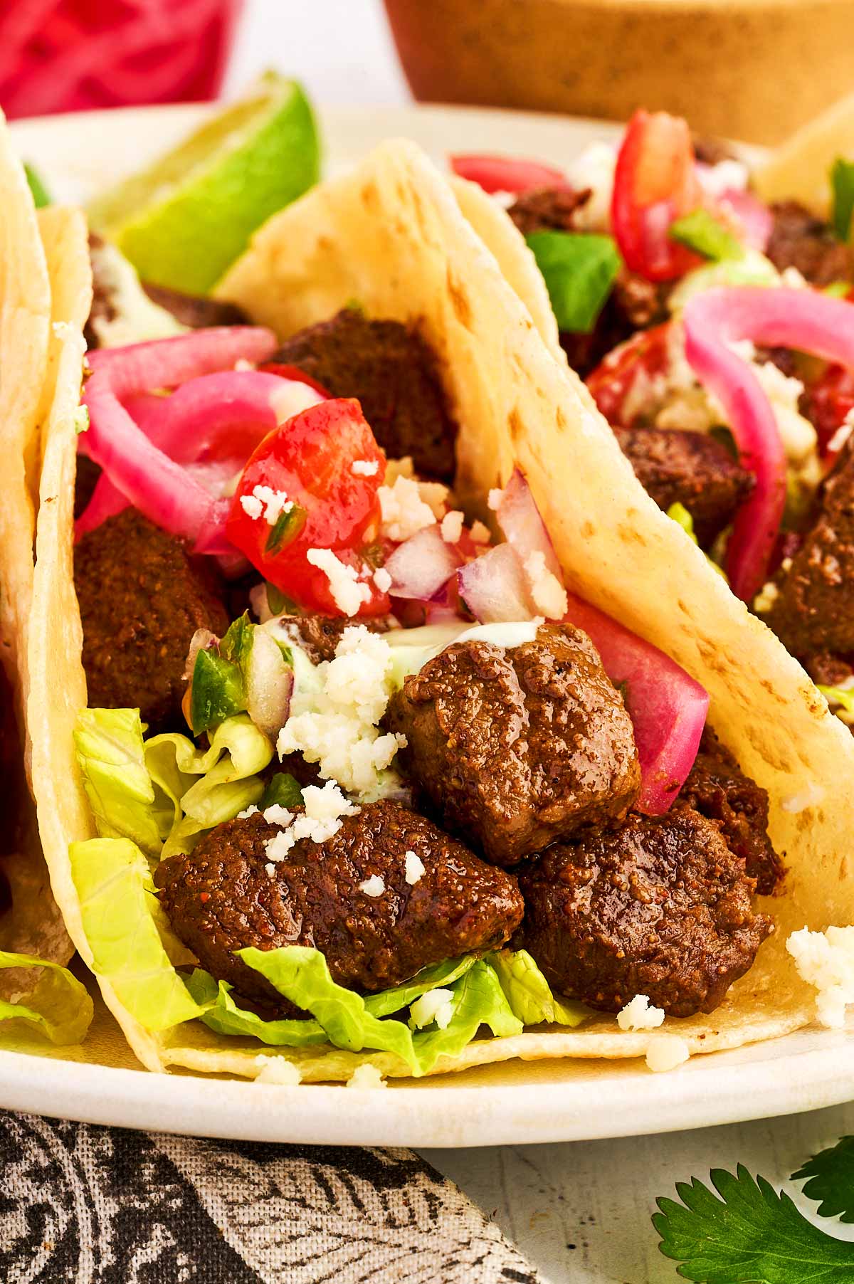 Steak taco with toppings on a white plate.