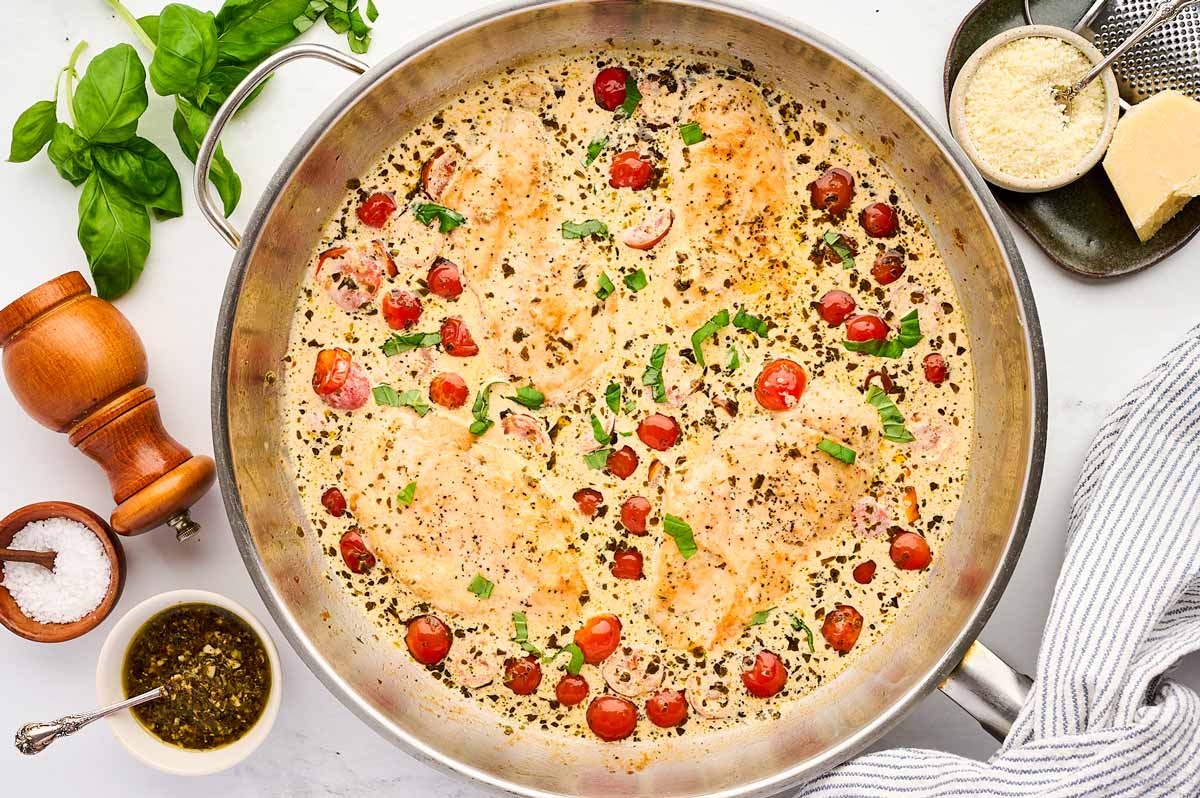 Skillet with creamy pesto chicken.
