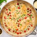 Skillet with creamy pesto chicken.