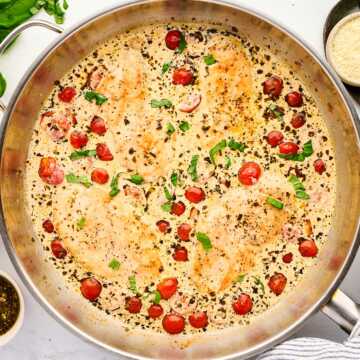 Skillet with creamy pesto chicken.