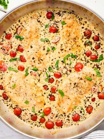 Skillet with creamy pesto chicken.