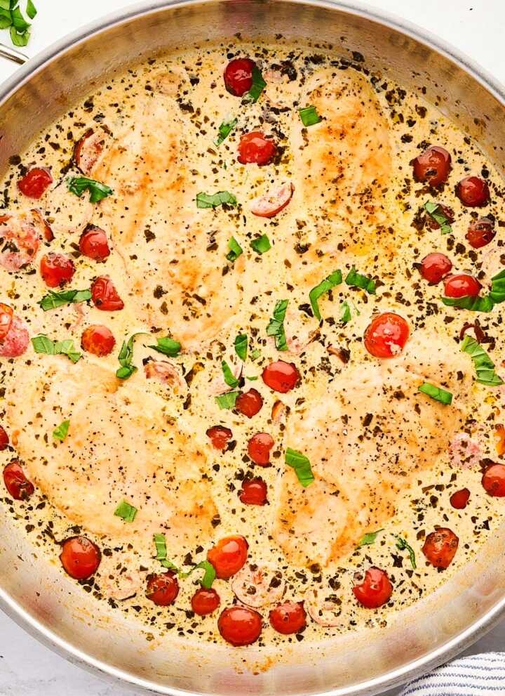 Skillet with creamy pesto chicken.
