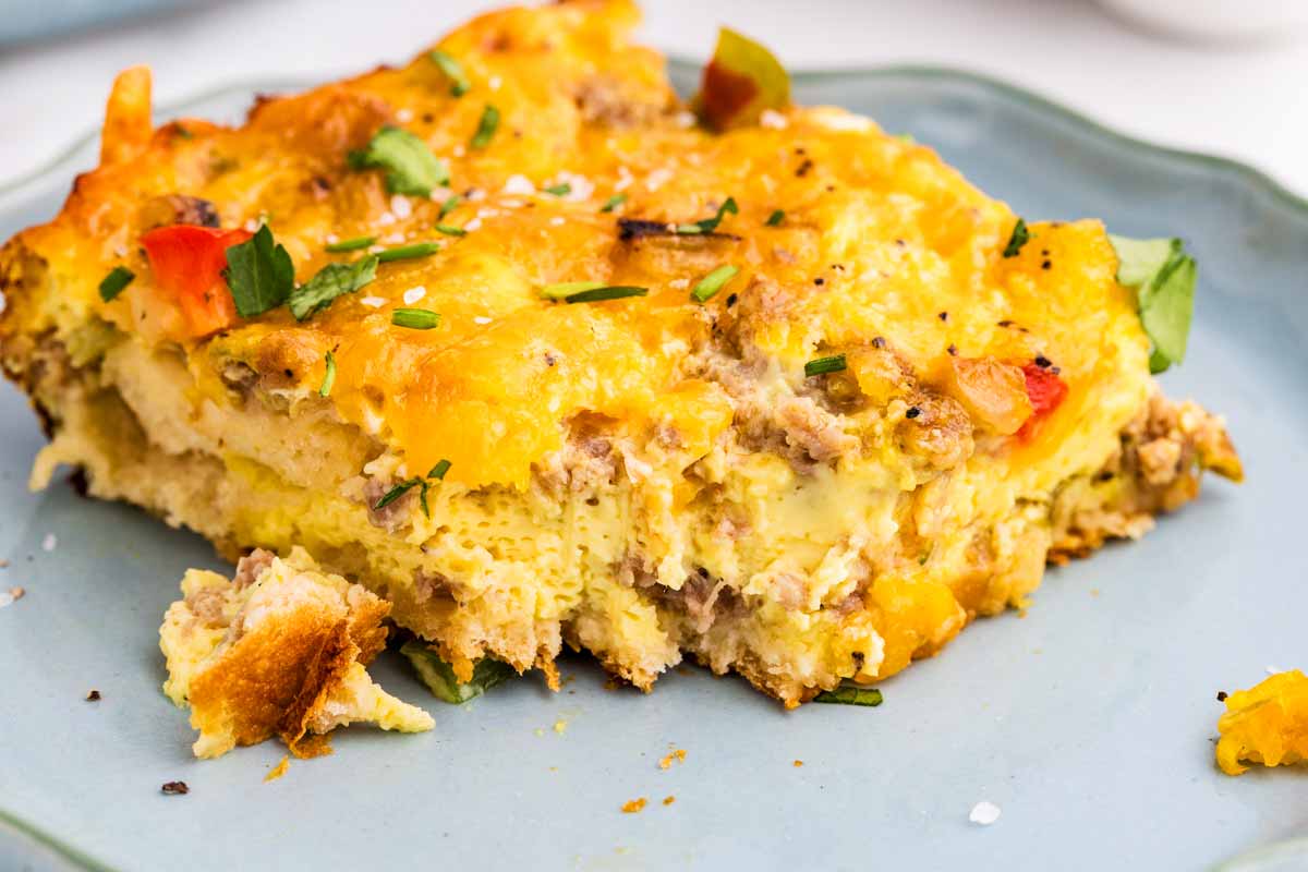 Slice of breakfast casserole on a blue plate.