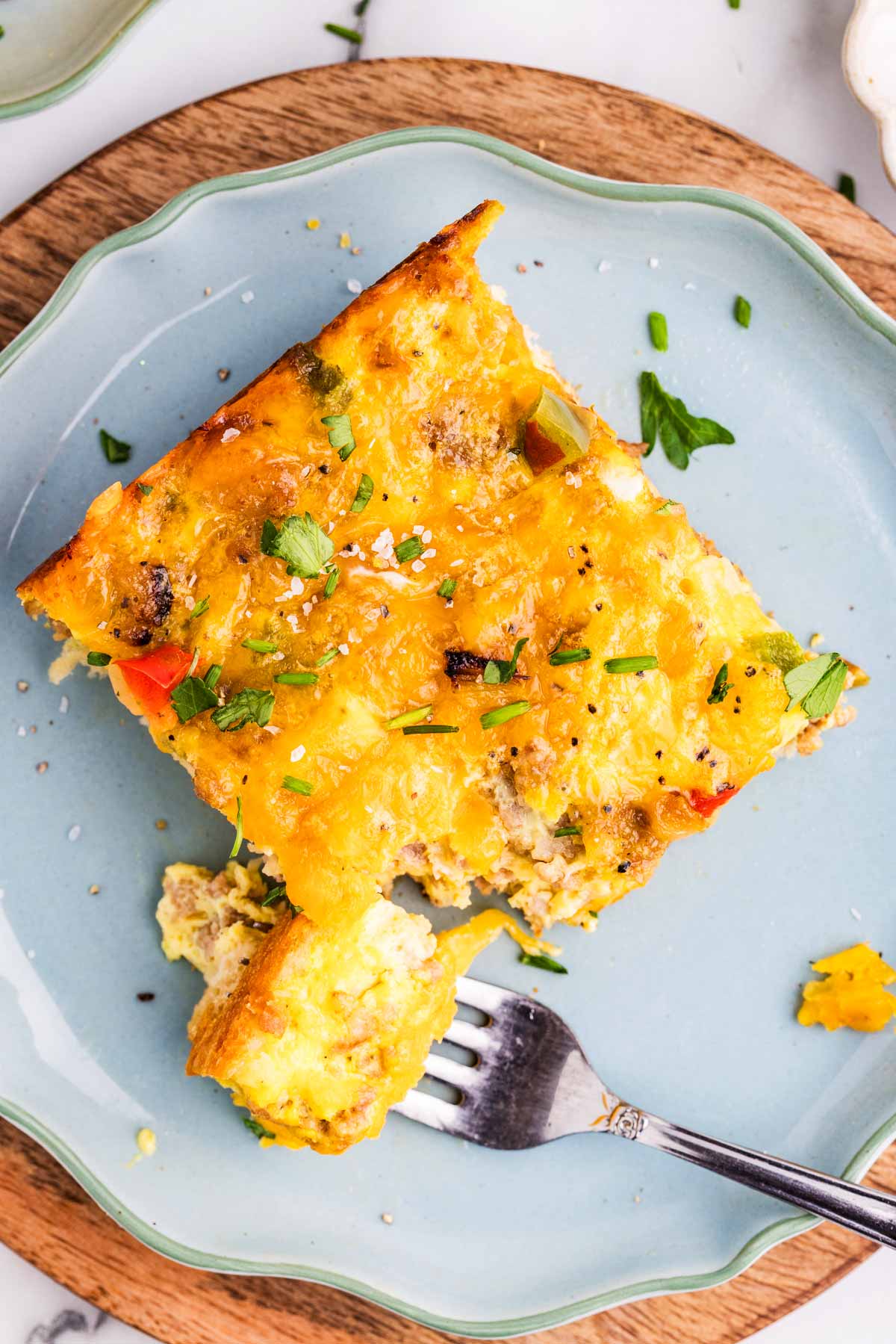 Slice of breakfast casserole on a blue plate.