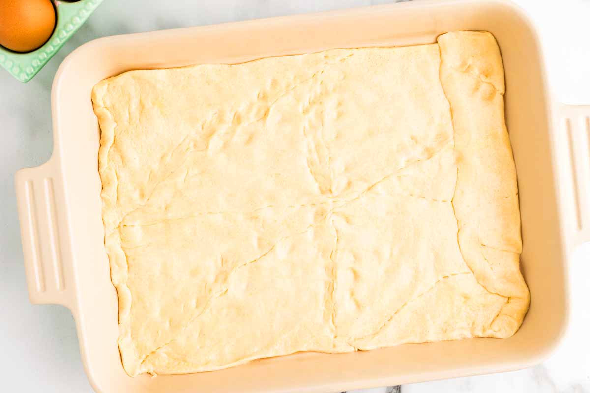Crescent roll dough in ceramic baking dish.