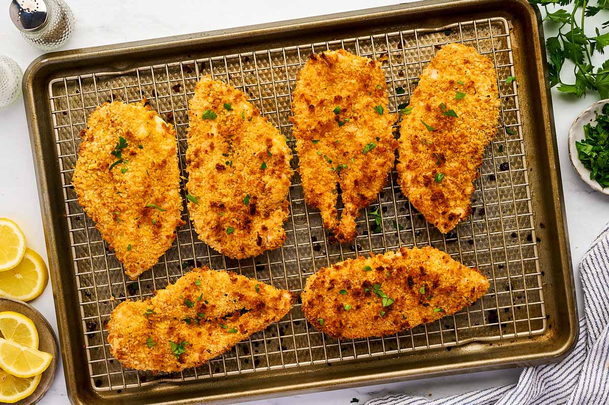 Baked chicken cutlets on rack.