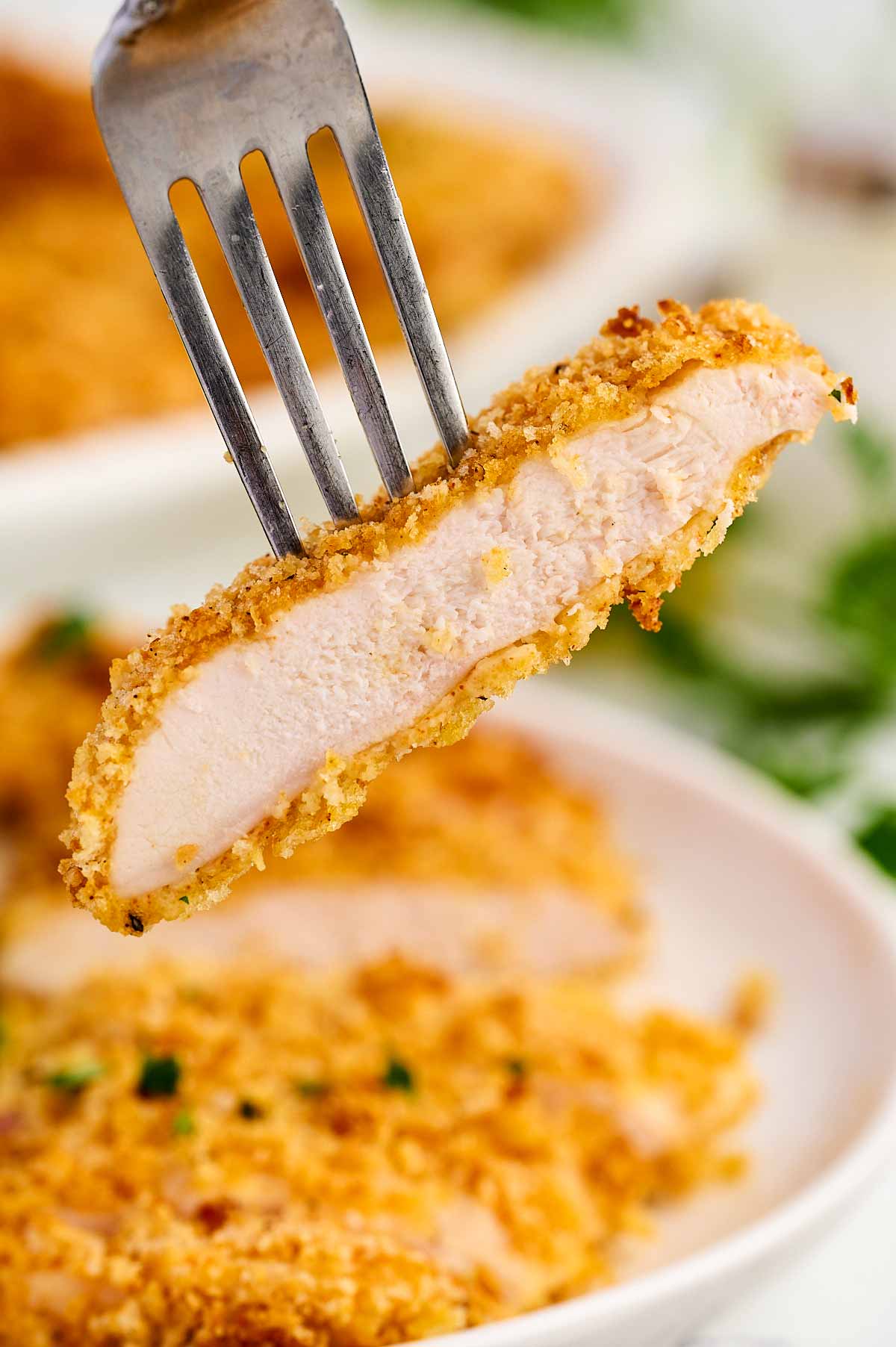 Fork with a slice of chicken cutlet.