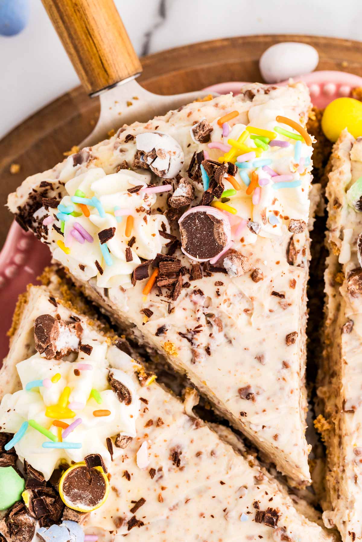 Close up photo of a lice of cheesecake with mini eggs for Easter.