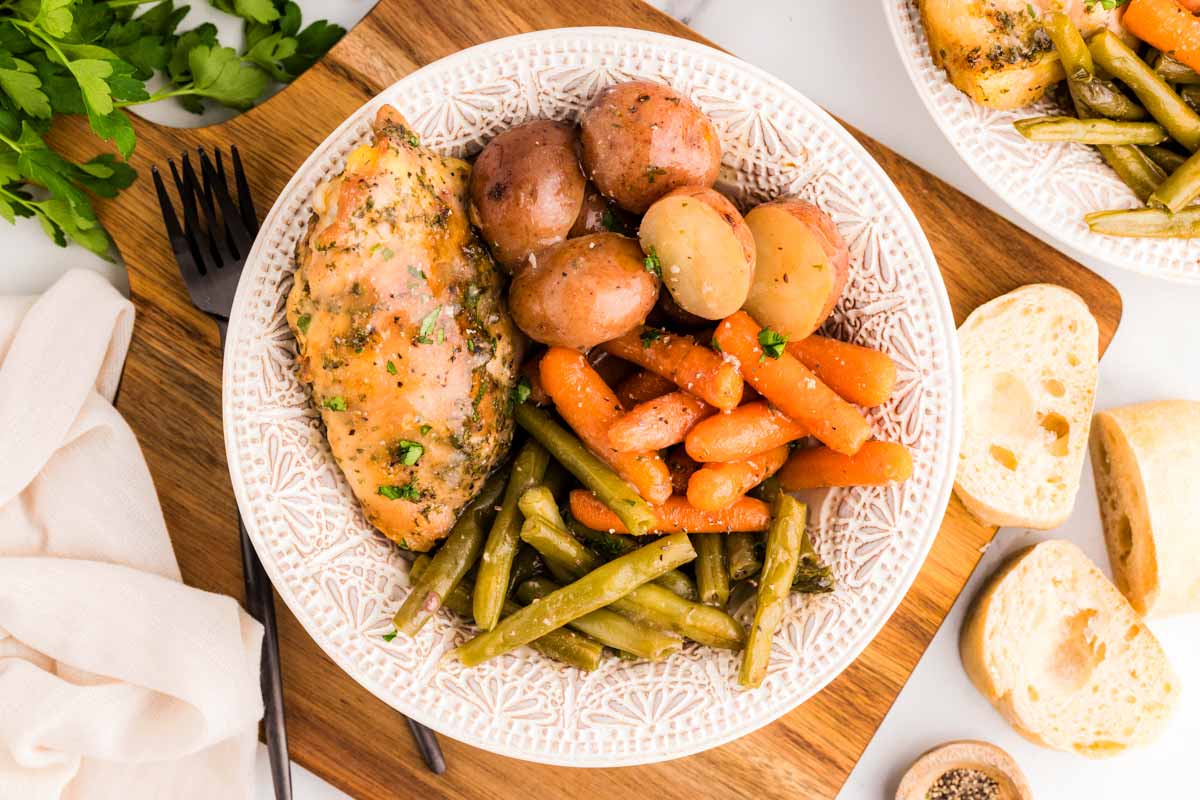 Serving chicken thighs and vegetables on a plate.