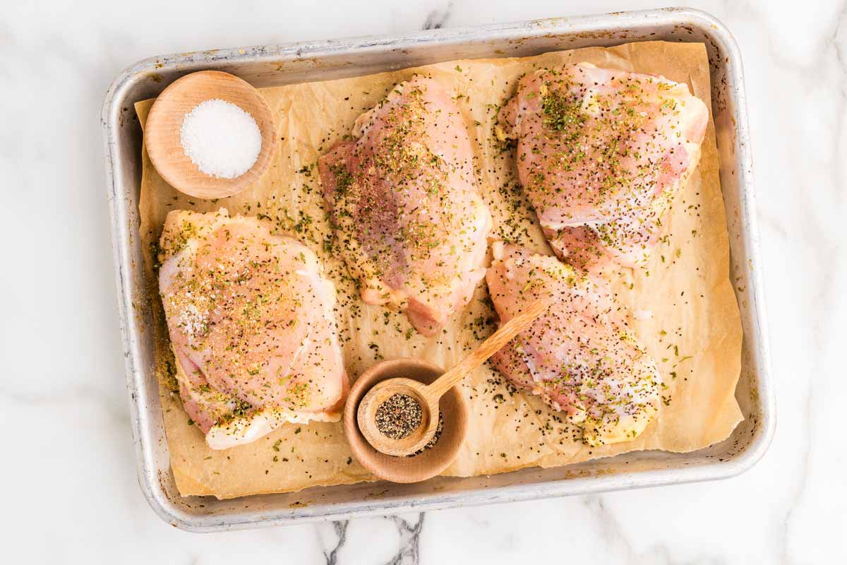Seasoning chicken thighs.
