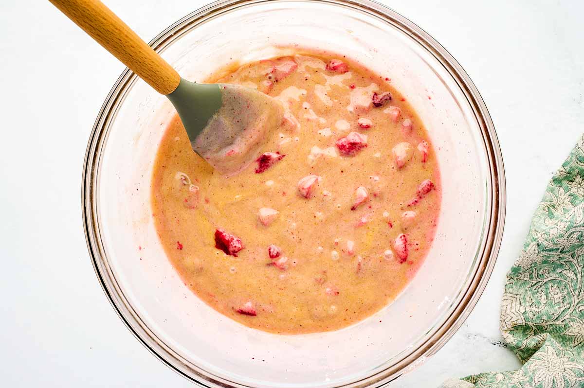 Batter for strawberry bread in glass bowl after adding the strawberries.