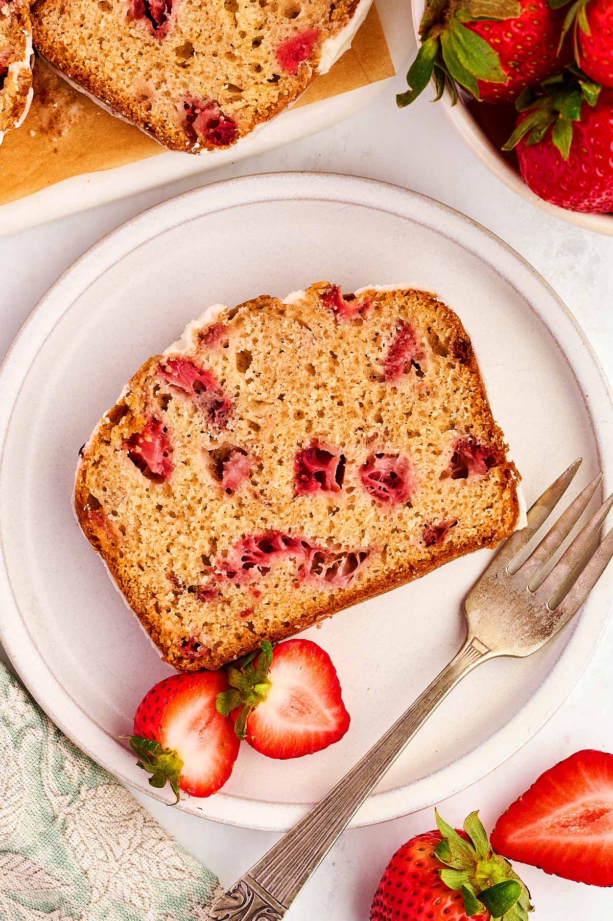 Plate with slice of strawberry bread.
