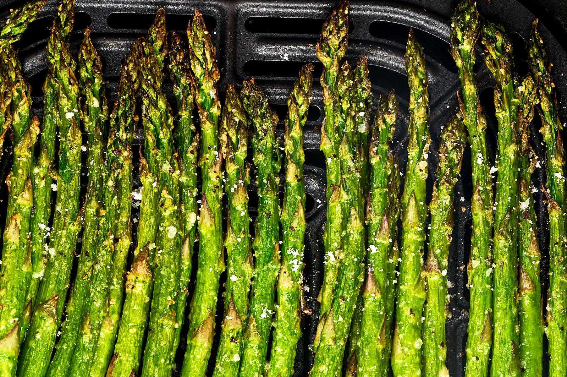 Asparagus in air fryer basket.
