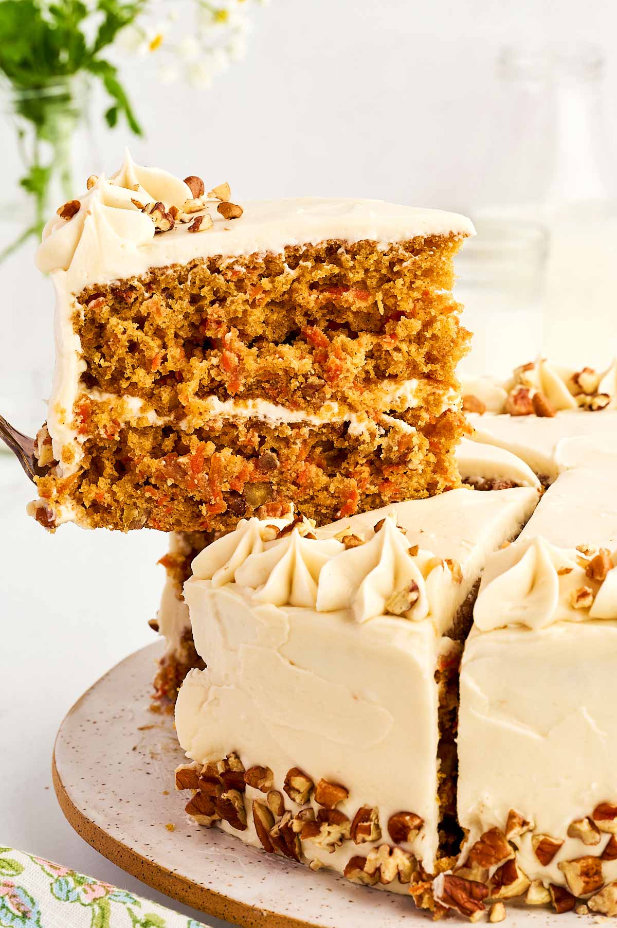 Lifting a slice of carrot cake with a cake server.