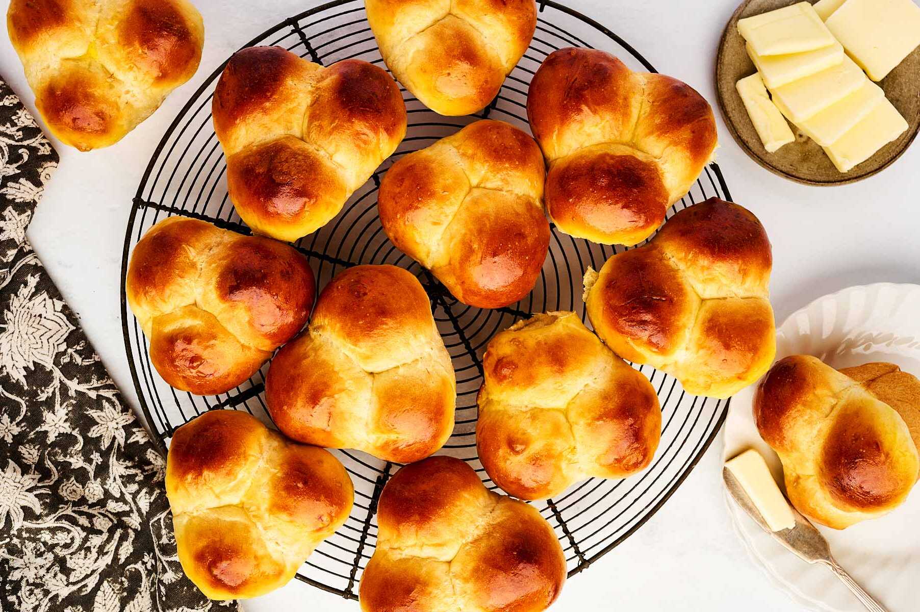 Cloverleaf rolls on a black cooling rack.