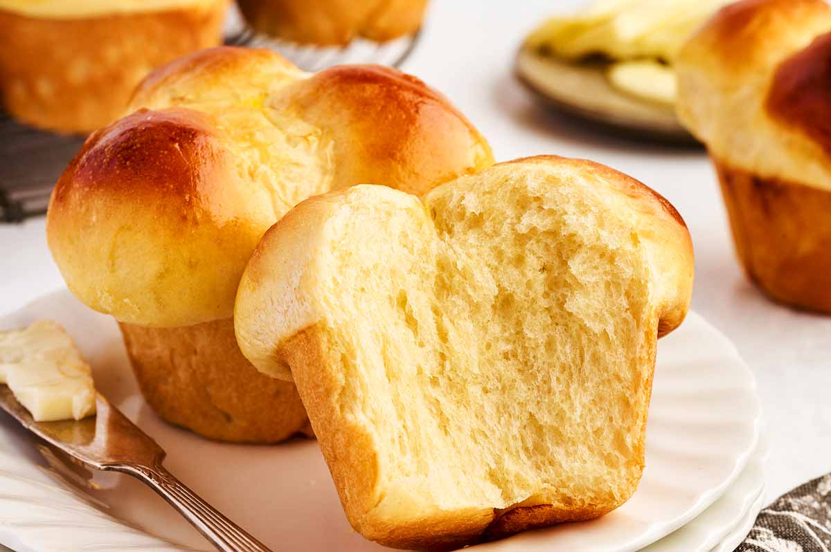 Two cloverleaf dinner rolls on a white plate.