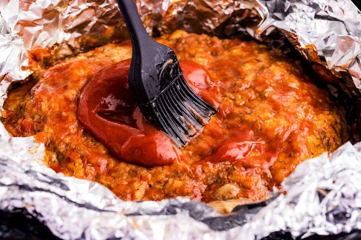 Brushing glaze on meatloaf.