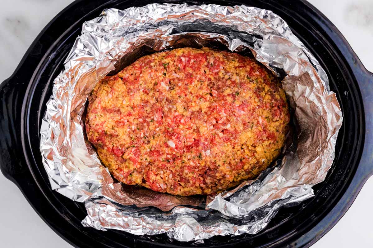 Uncooked meatloaf in crockpot.