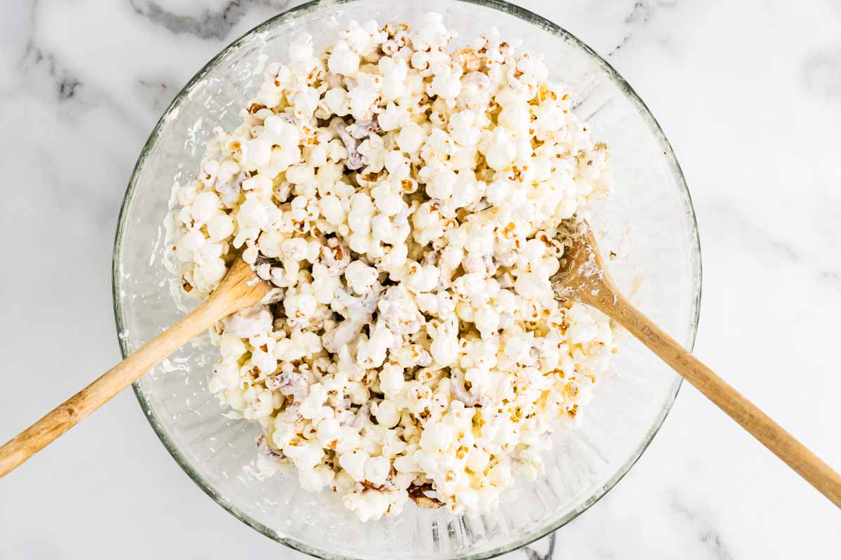 Tossing popcorn with melted white chocolate.