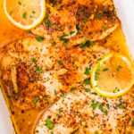 Garlic Butter Baked Tilapia in a white casserole dish.