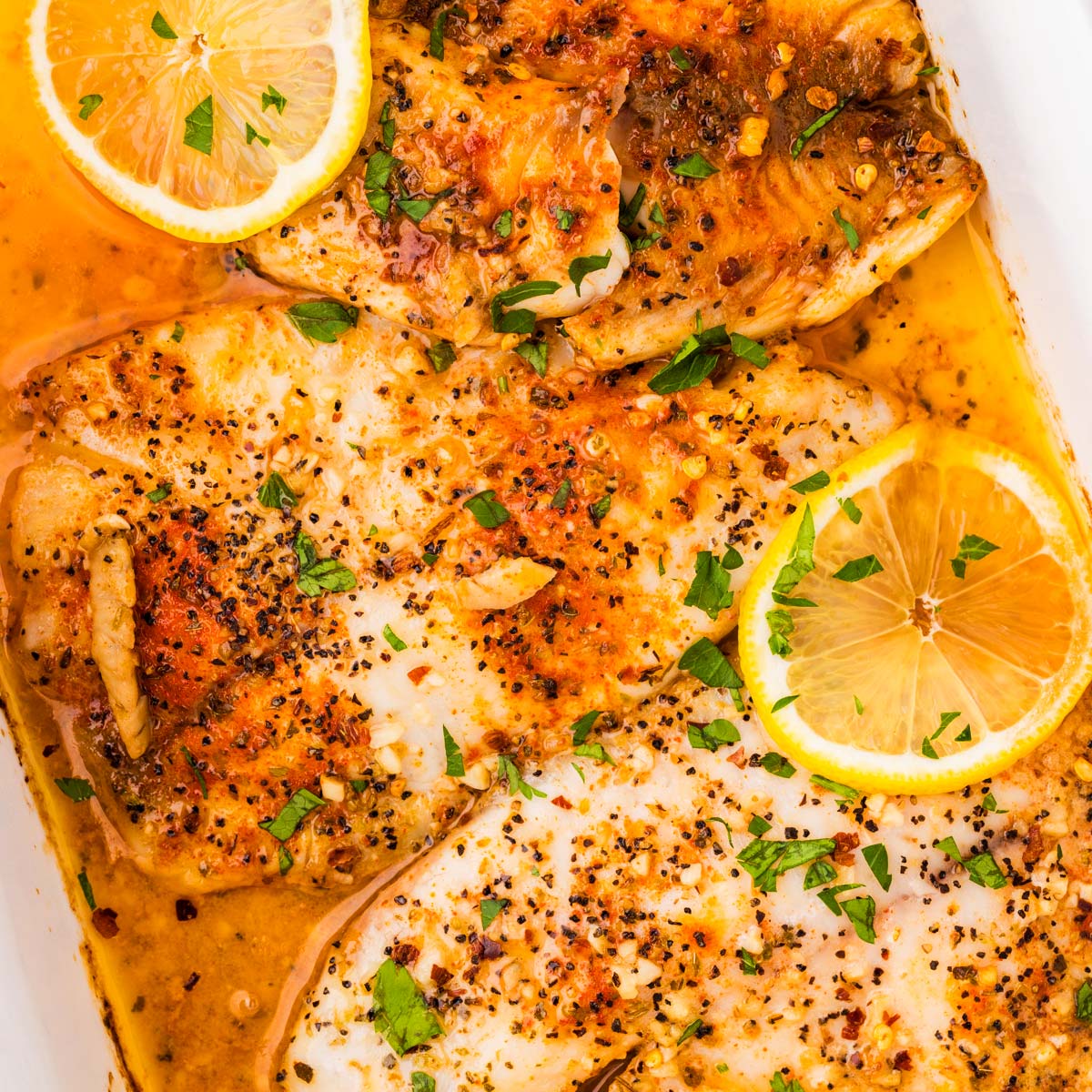 Garlic Butter Baked Tilapia in a white casserole dish.