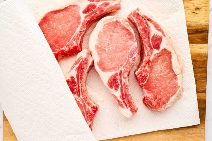 Pork chops patted dry with paper towels.