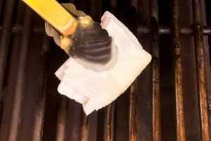 Oiling grates of a charcoal grill.