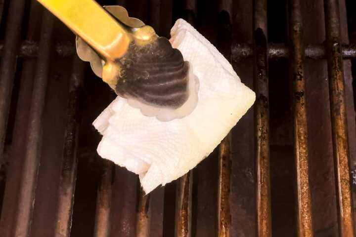 Oiling grates of a charcoal grill.