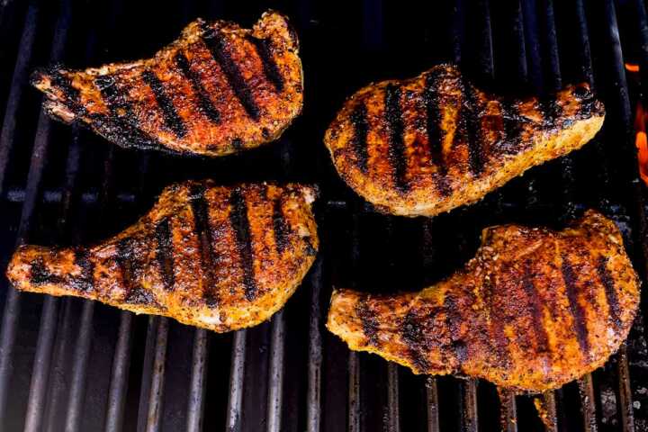 Grilled pork chops on a charcoal grill.
