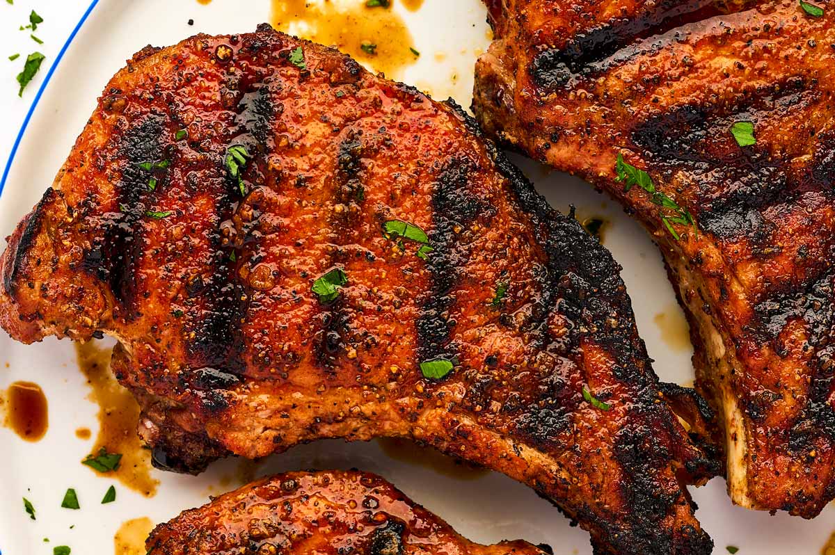 Grilled pork chops on a white plate.