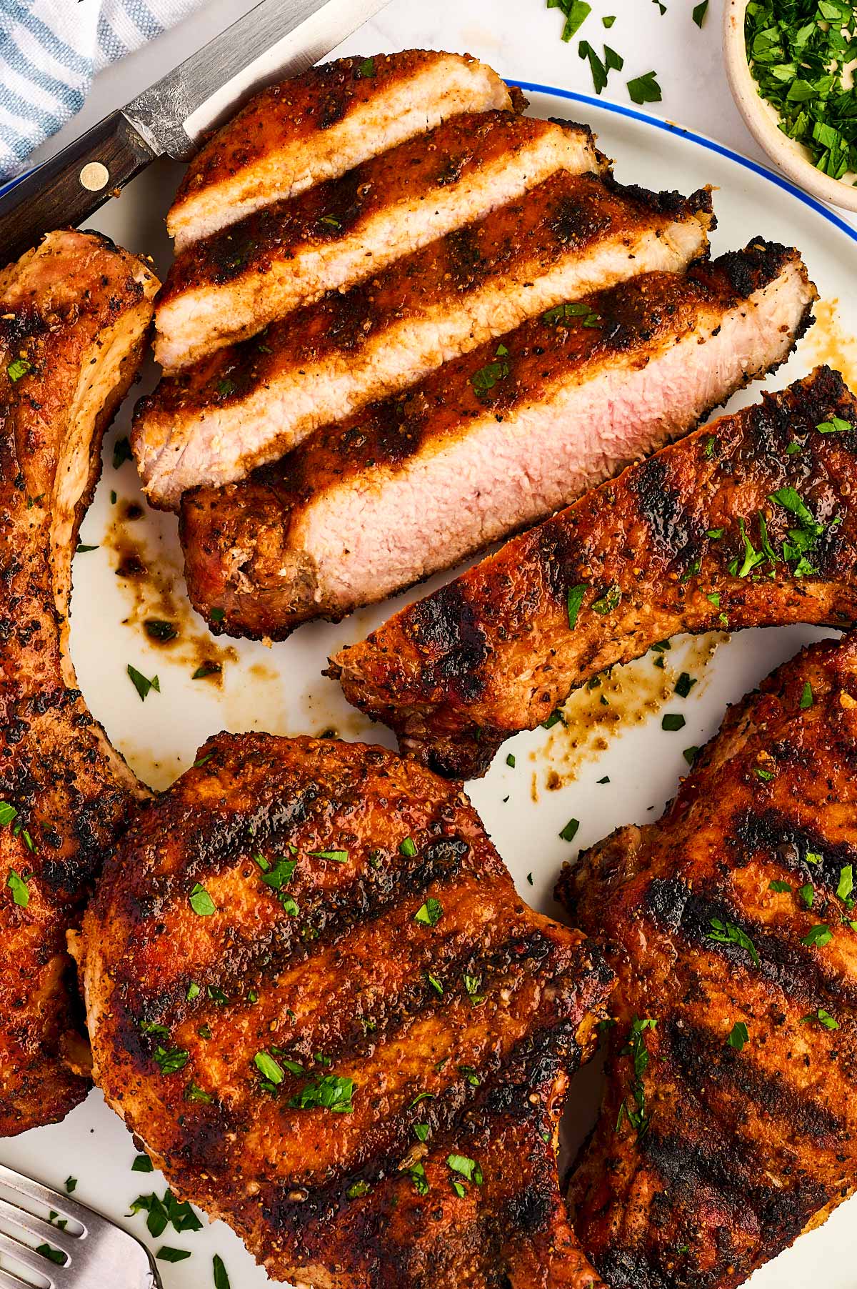 Plate of whole and sliced grilled pork chops.