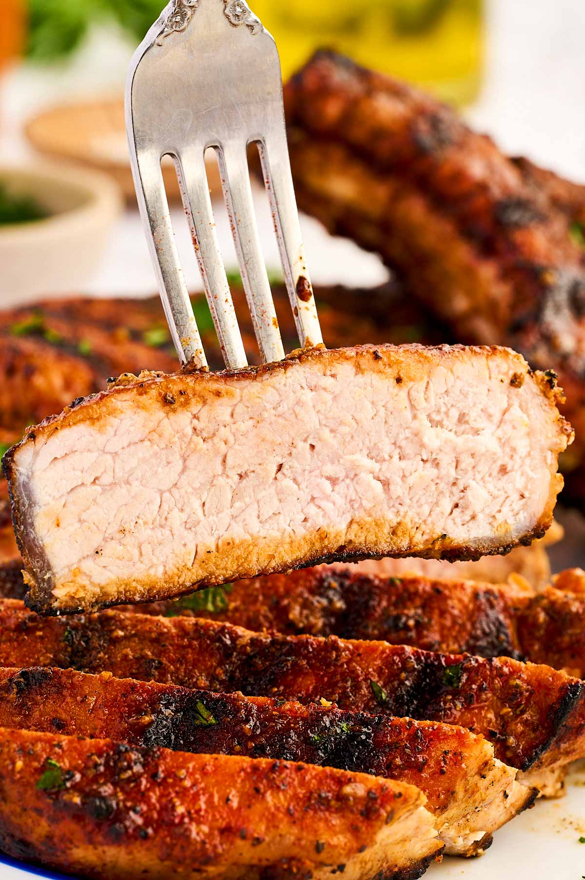 Slice of grilled pork chop on a fork.